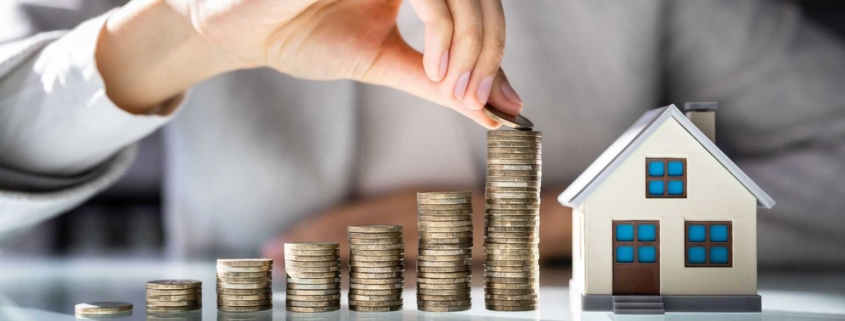 Immobilienbewertung Berg am Laim: Münzstapel neben einem Hausmodell