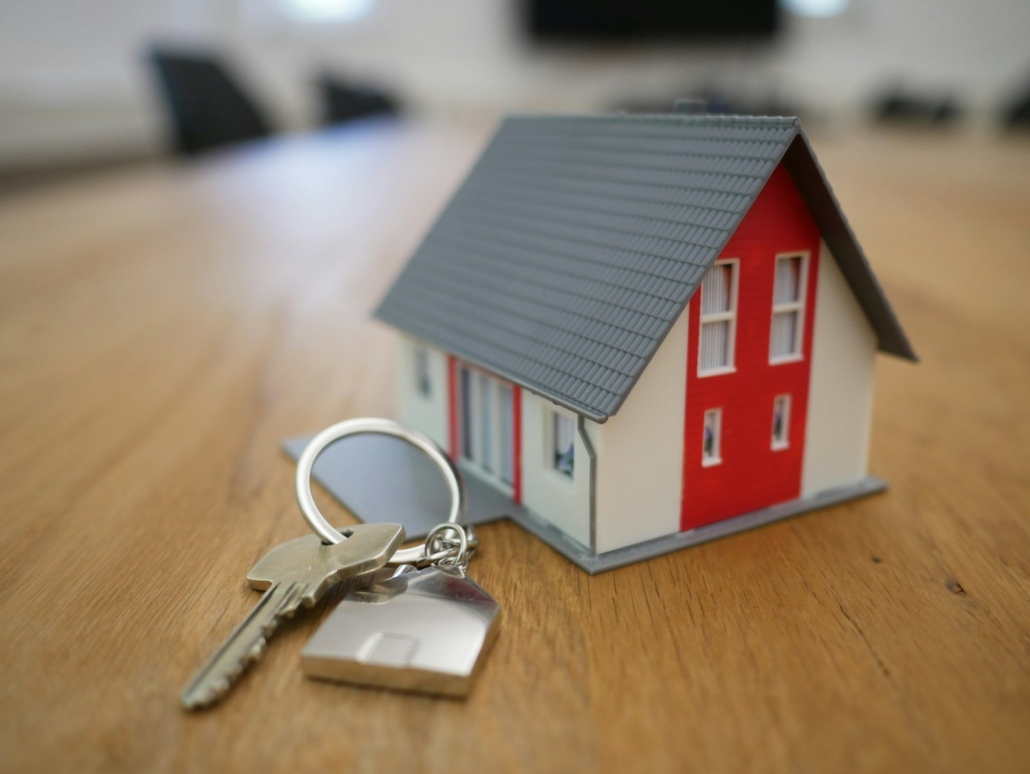 Professioneller Immobilienmakler Haidhausen: Hausmodell mit Schlüsselbund auf dem Tisch